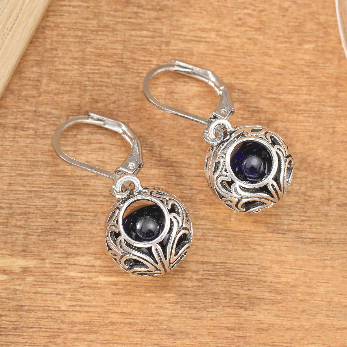 Vintage silver hollow pendant earrings with blue gemstone accent on geometric drop shape