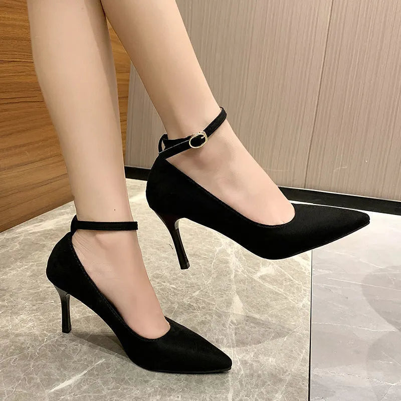 Women's black stiletto heel pump shoes with skull pattern and buckle detail on a white background