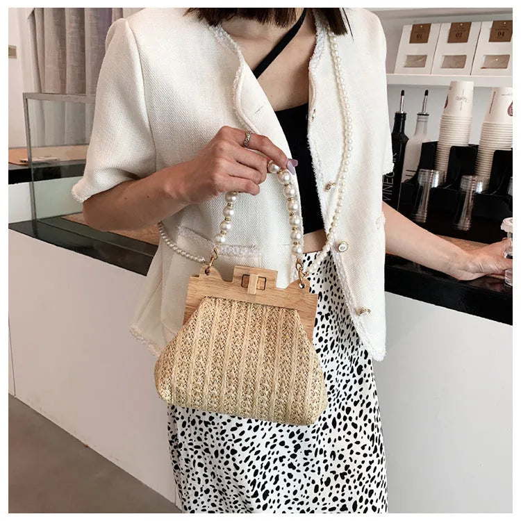 Women's woven straw shoulder bag with pearl chain detailing and multiple interior compartments