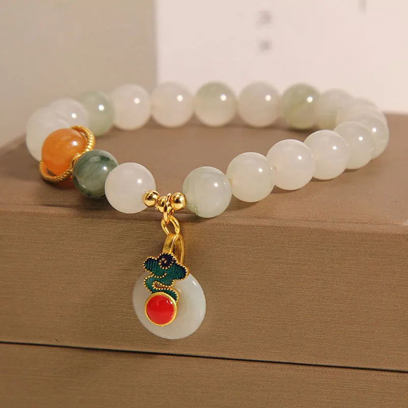 Women's ice jade bracelet with pearl accents and a Xiangyun jade buckle on a wrist.