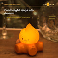 Cartoon-style silicone small fire pile night lamp with yellow glow on a table
