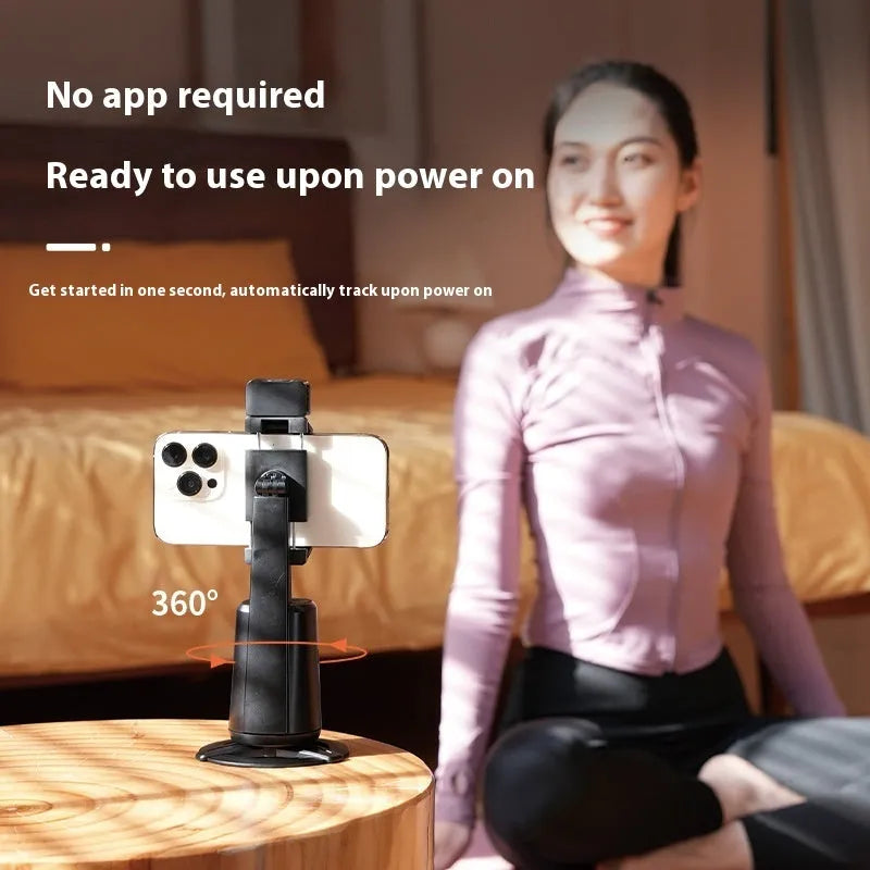 Black desktop phone bracket with intelligent face tracking camera and LED ribbon lights, remote control on desk