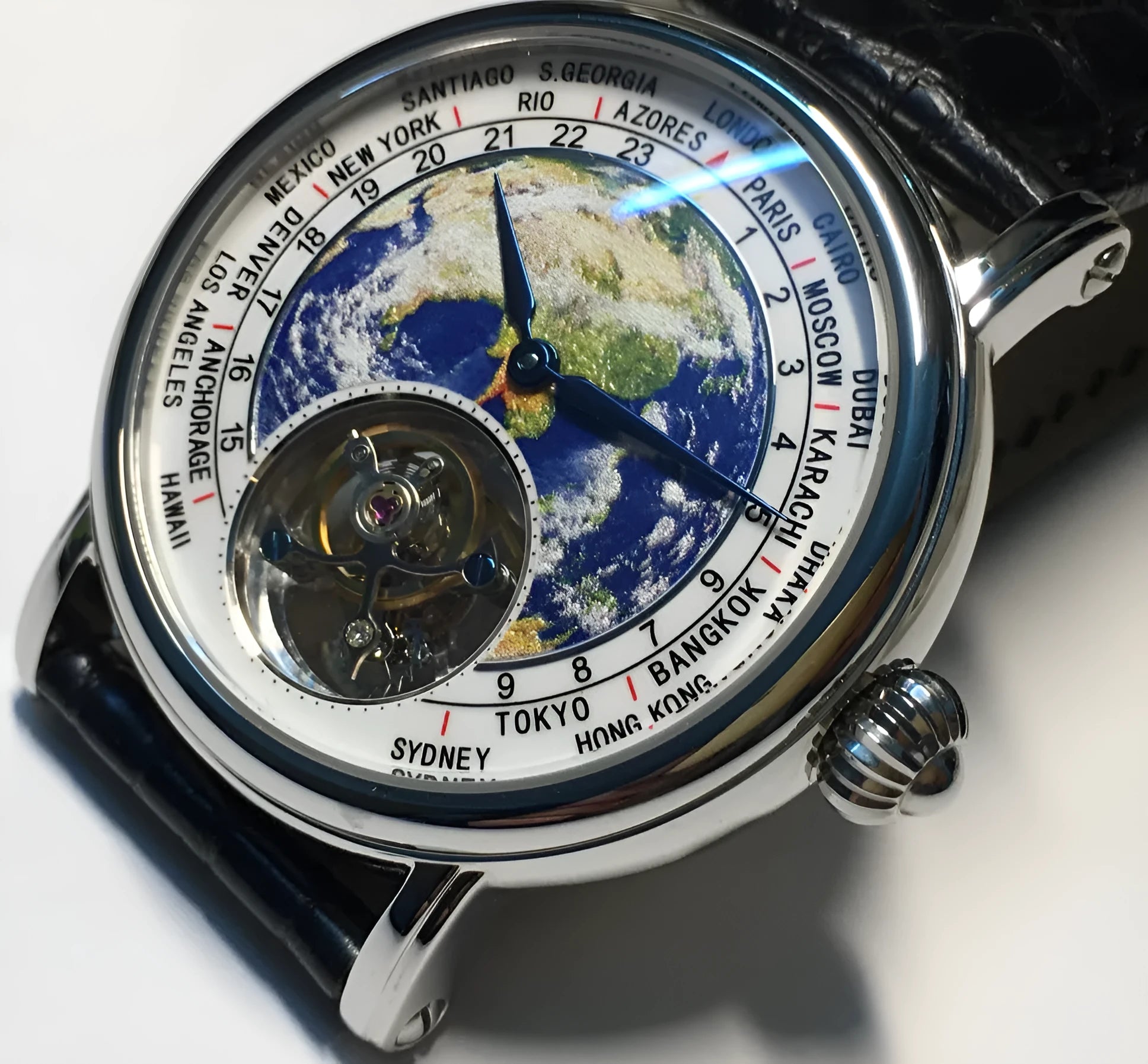 Silver 3D globe tourbillon mechanical watch with leather band and stainless steel case on white background