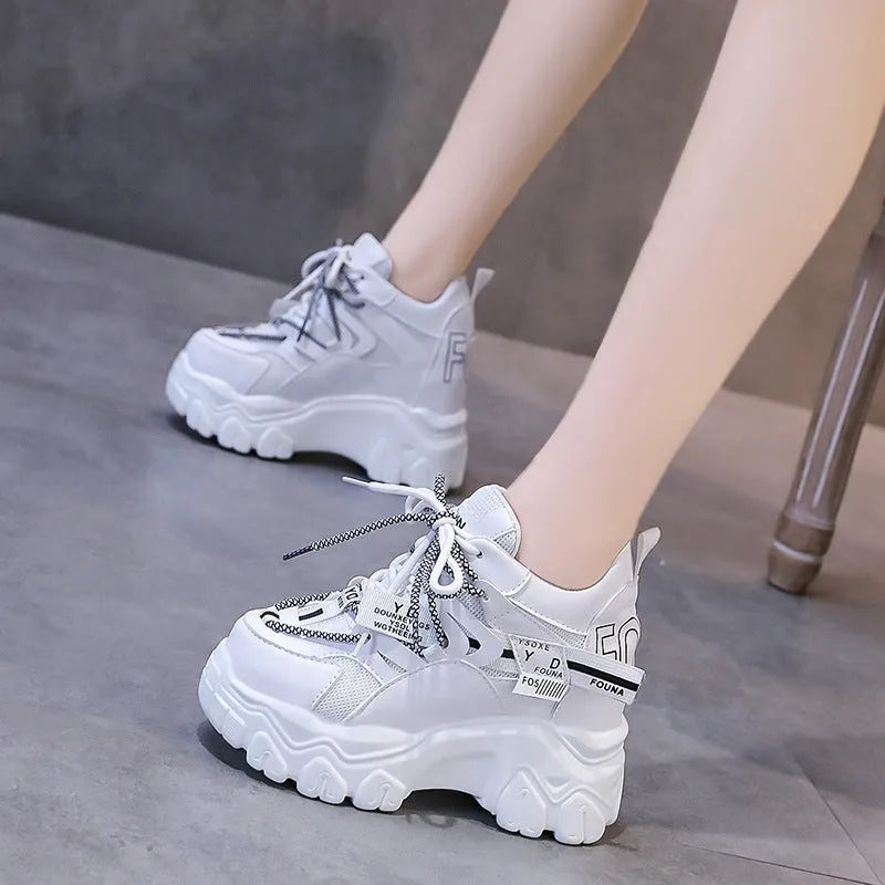 White and black women's low-top platform sports shoes with mesh upper and cross strap.
