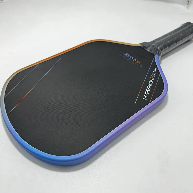 Matte black pickleball racket with Teflon cloth pattern, showing carbon fibre construction and honeycomb core.