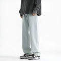 Men's light blue washed straight leg jeans with button waist closure on size chart background