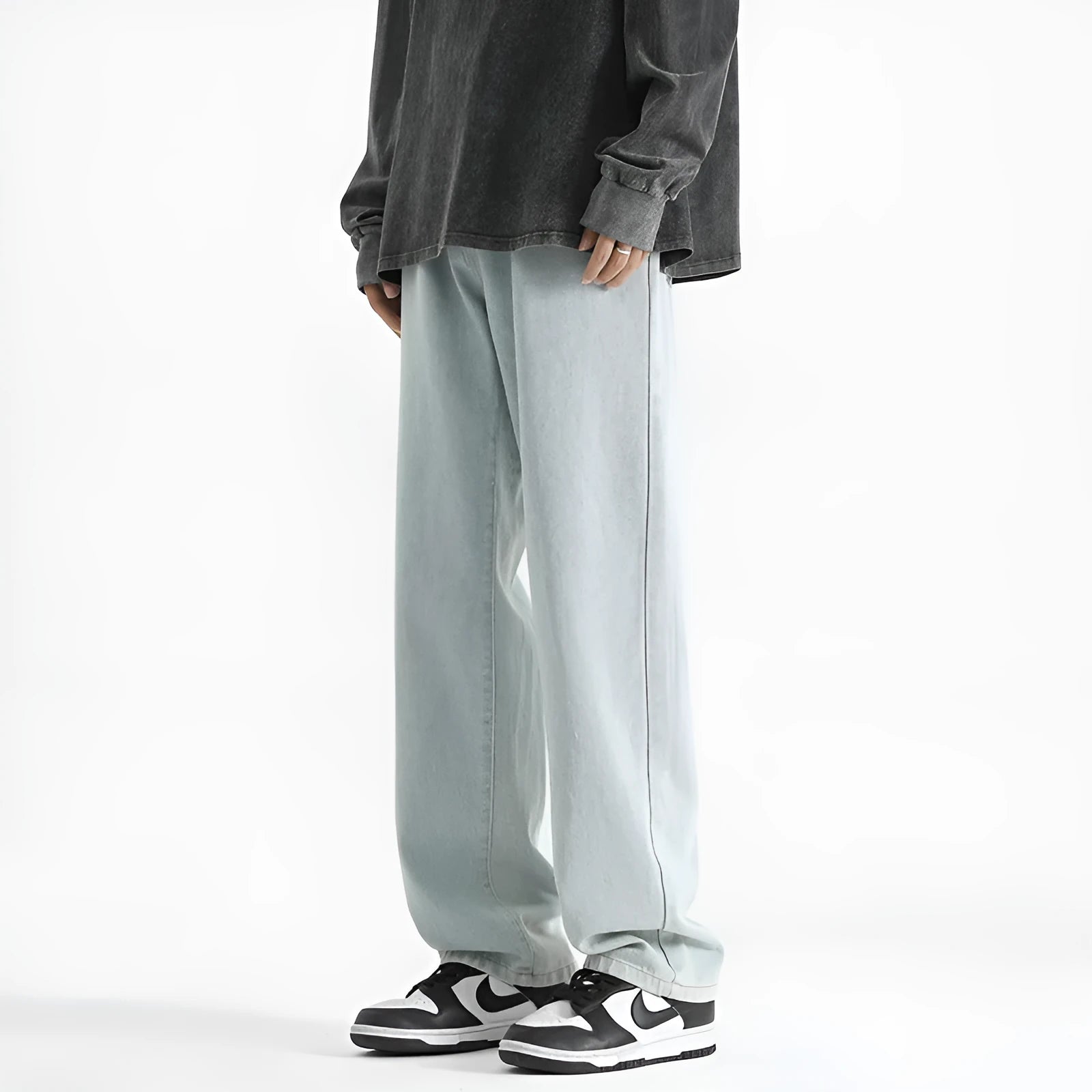 Men's light blue washed straight leg jeans with button waist closure on size chart background