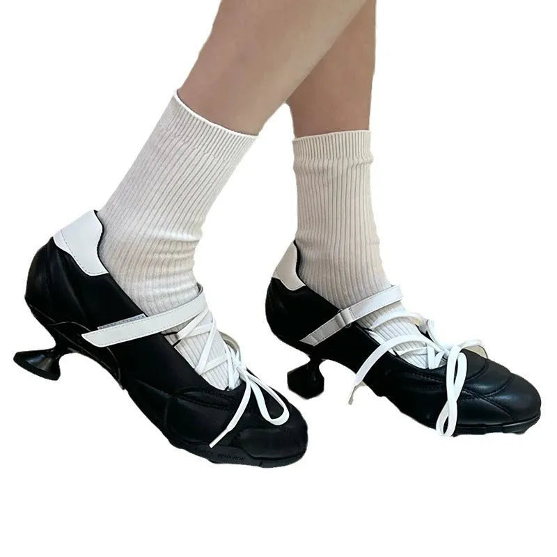 Women's silver low-top sports shoes with front lace-up, bow detail, and a mid heel on a white background.