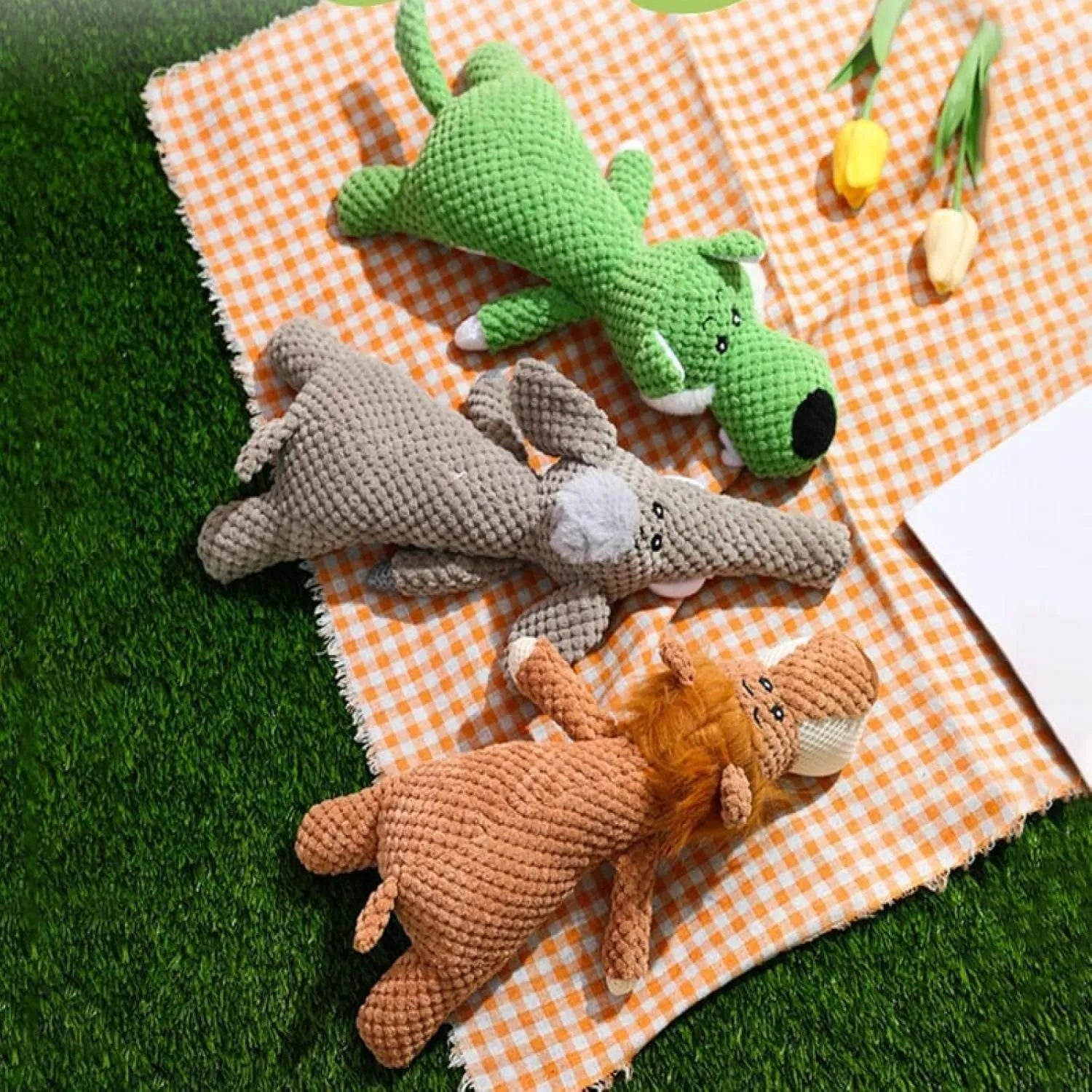 Green, grey, and yellow plush dog chew toy with textured surface and animal shape.