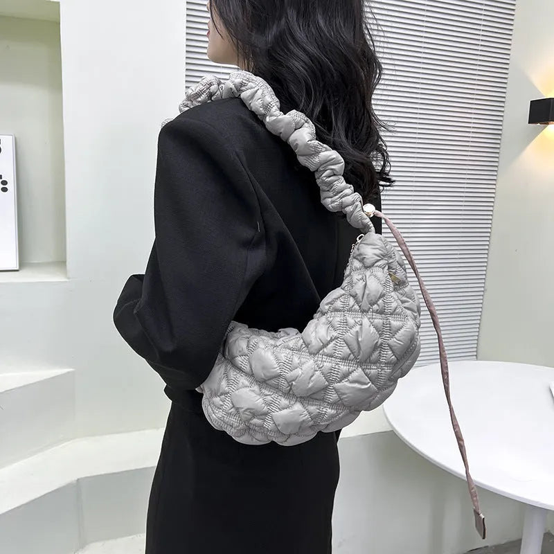 Women's light beige nylon underarm messenger bag with a long shoulder strap.