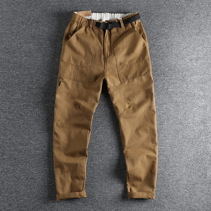Men's khaki trousers with N buckle belt closure and zipper fly on a mid-waist fit.