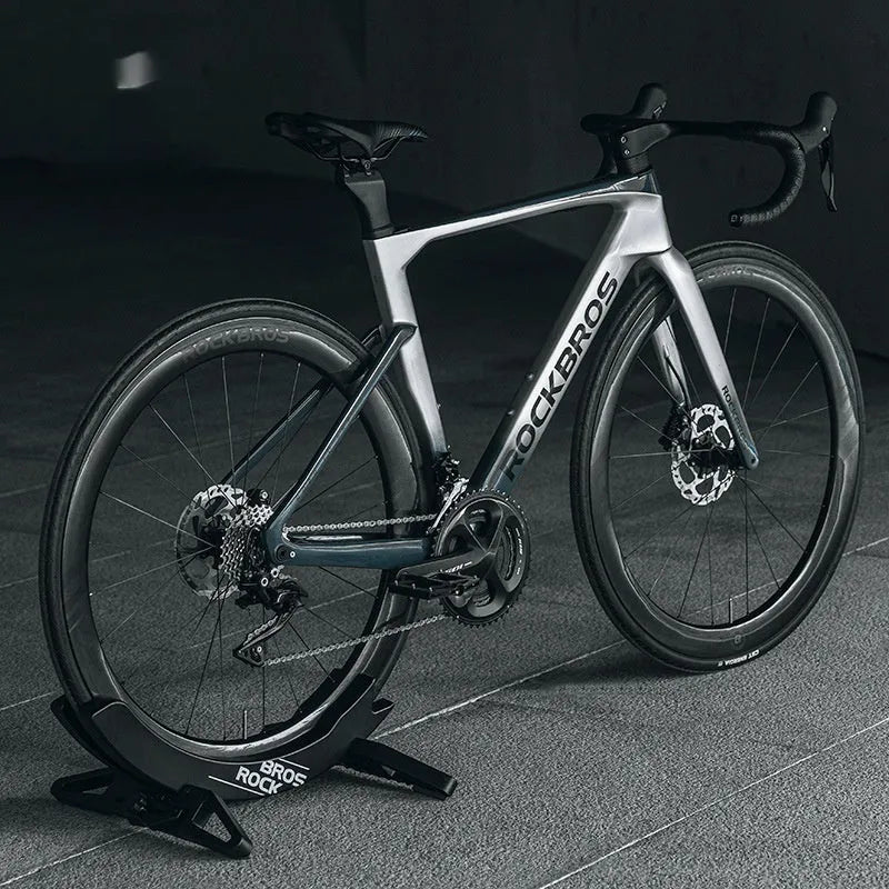 ABS wall-mounted bike parking rack holder in black holding a bicycle frame against a garage wall