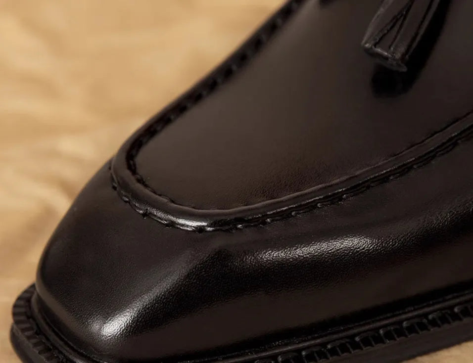 Men's black leather slip-on loafers with fringed detail and rubber sole