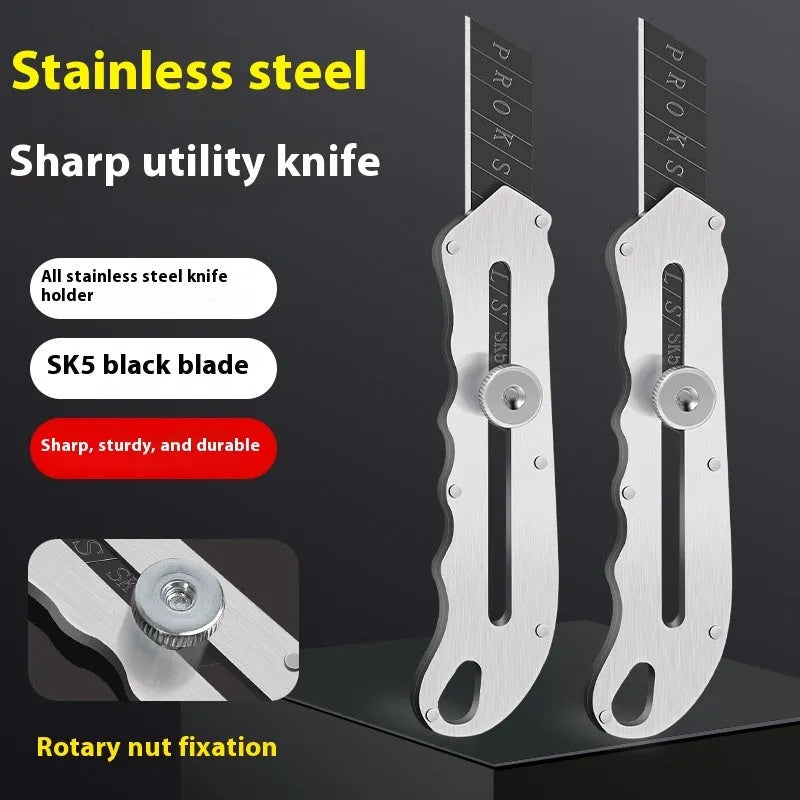 Stainless steel folding art knife with black blade, showing open position on work surface
