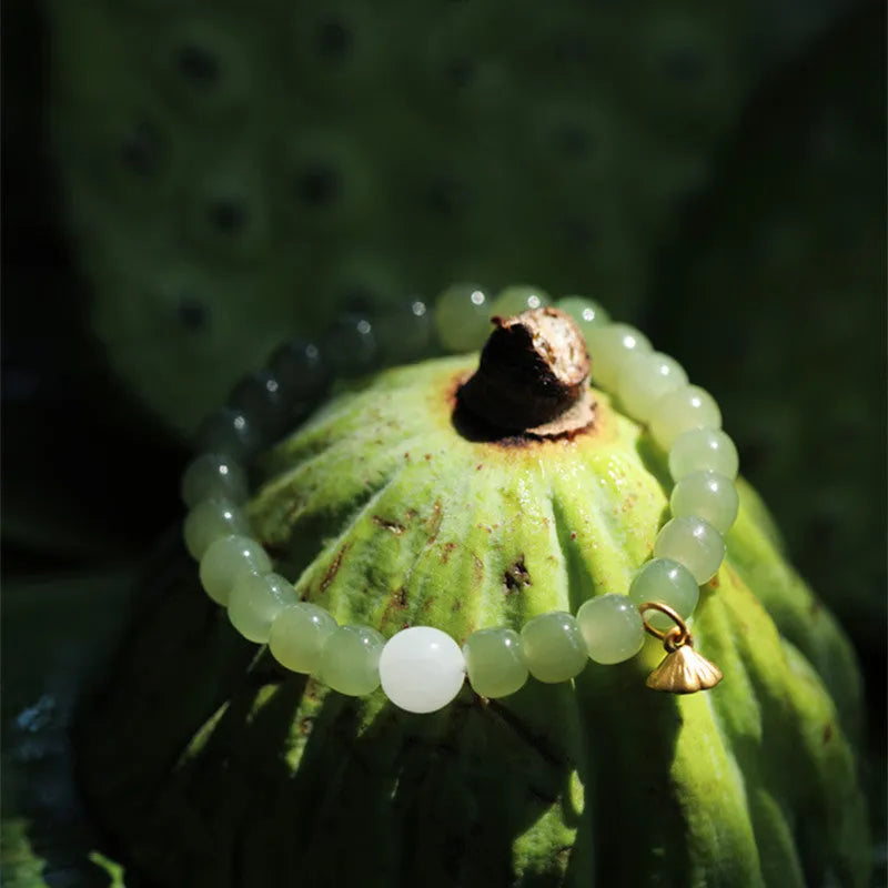 Green jade bracelet with vintage beads on white background, ethnic style women's jewellery