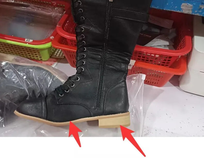 Women's black knee-high boots with cross strap design and knight boot styling