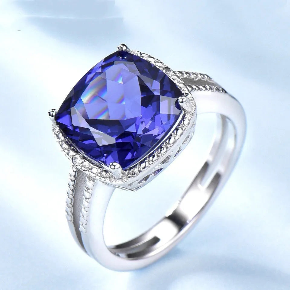 Blue Tanzanite gemstone set in a sterling silver women's ring on a white background.