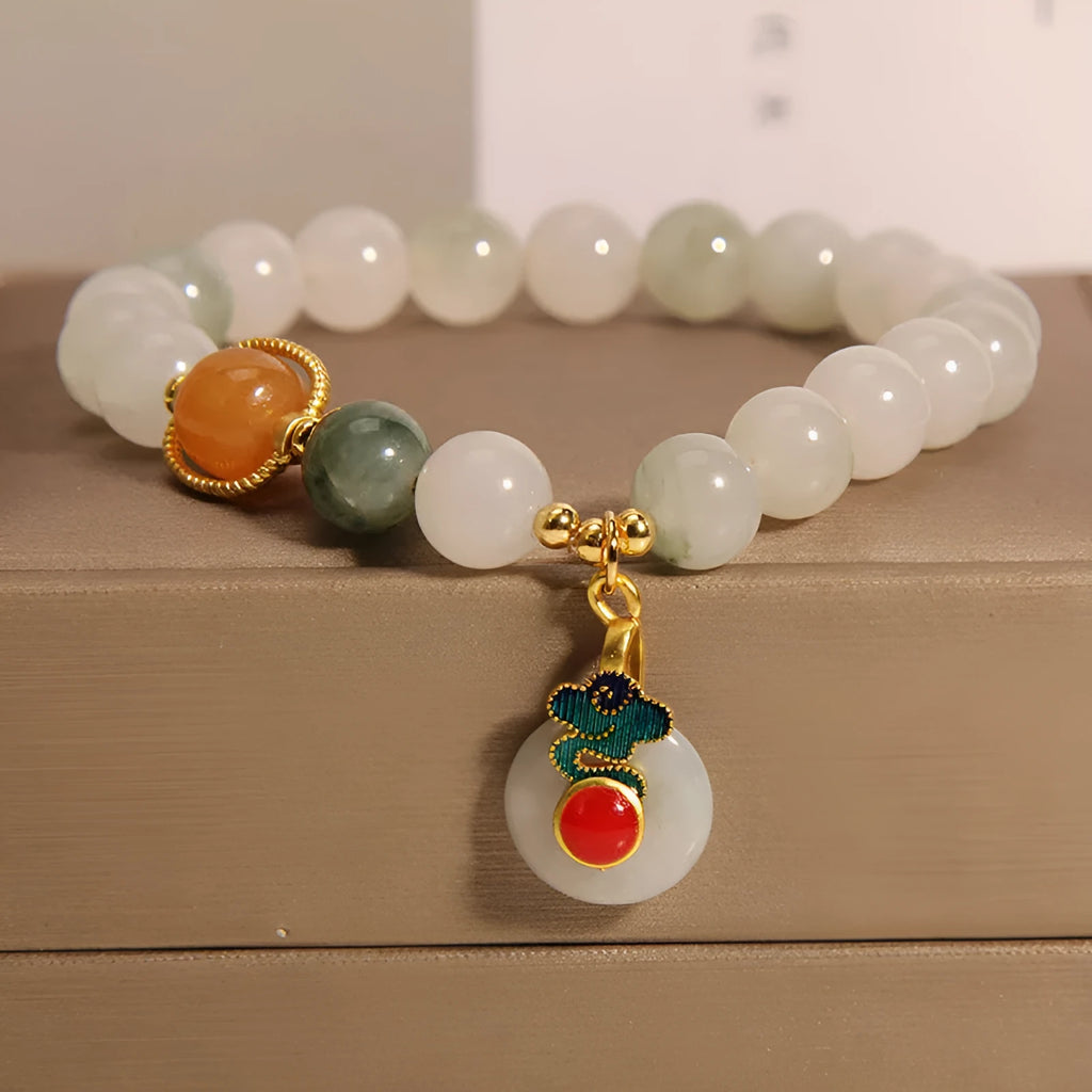 Women's ice jade bracelet with pearl accents and a Xiangyun jade buckle on a wrist.