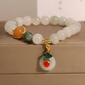 Women's ice jade bracelet with pearl accents and a Xiangyun jade buckle on a wrist.