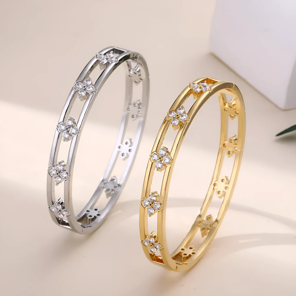 Gold and silver women's hollow bracelet with zircon inlay and a four-leaf clover design.
