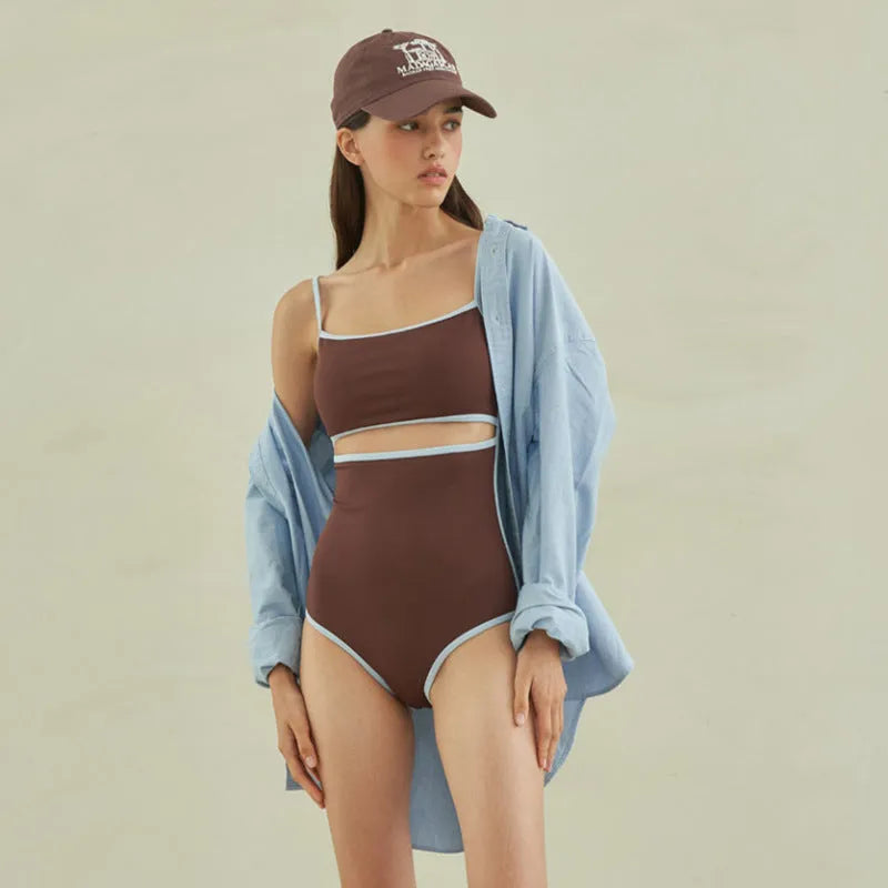 Brown women's one-piece triangle swimsuit on a hanger, showing front design.