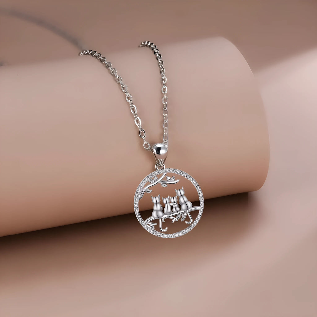 Close-up of a copper necklace featuring a pendant with four kittens in an original design, on a cross chain.
