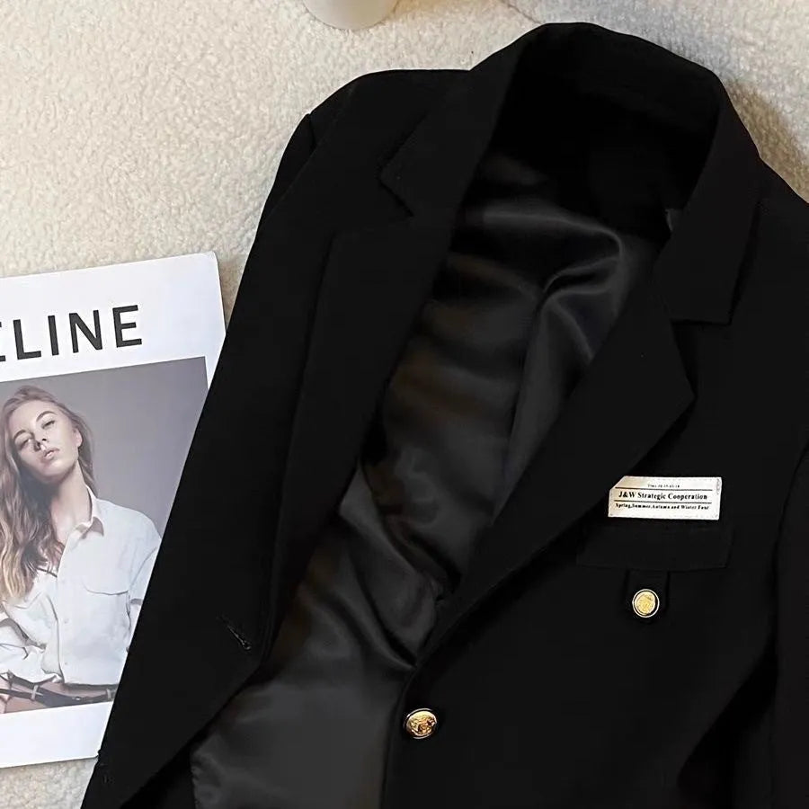 Women's black short suit coat with regular sleeves and pocket detailing