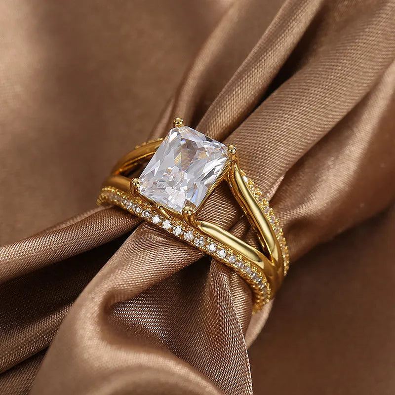 Gold geometric women's ring with a square zircon stone on a hand.