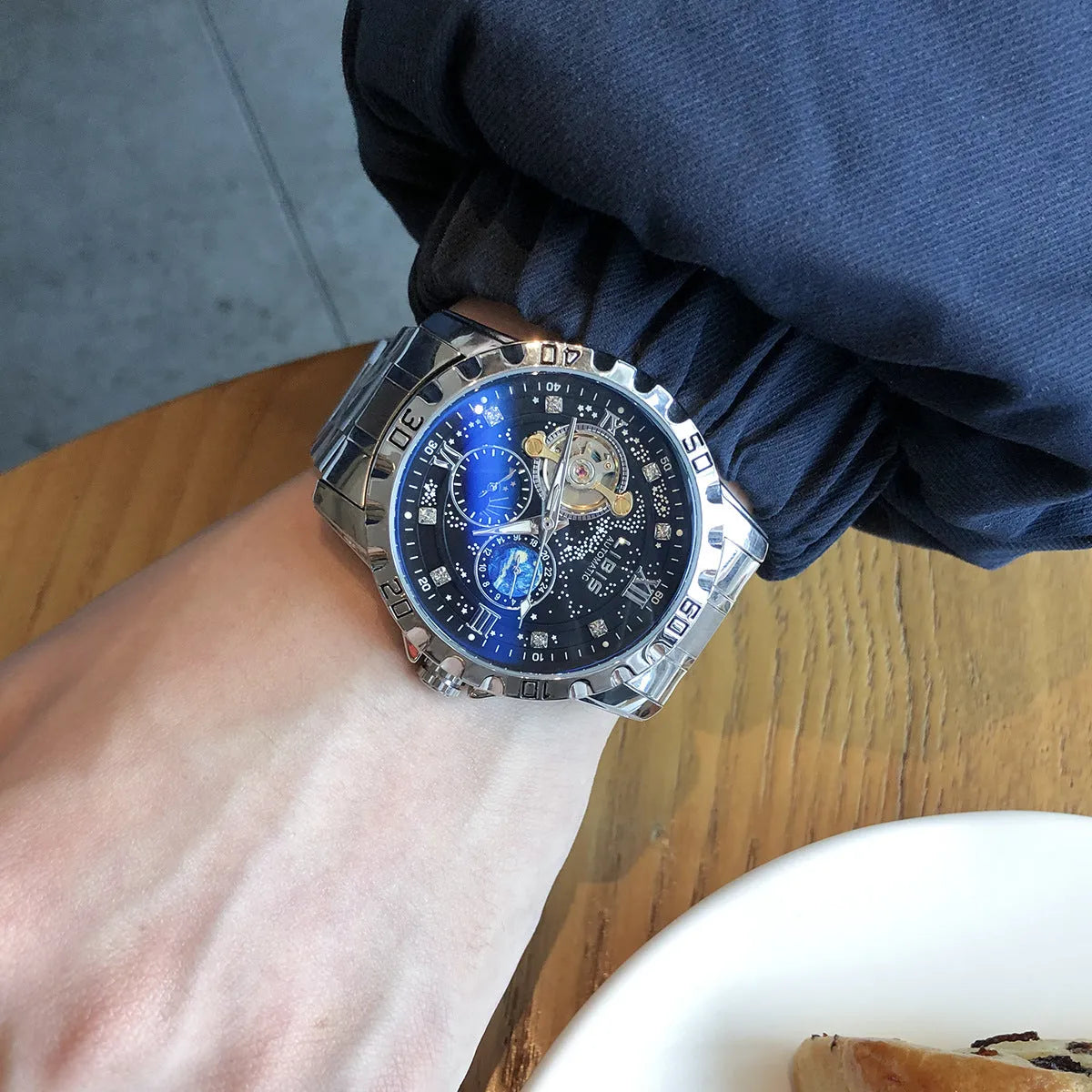 Men's silver case automatic watch with black dial, luminous hands and transparent mechanical case back