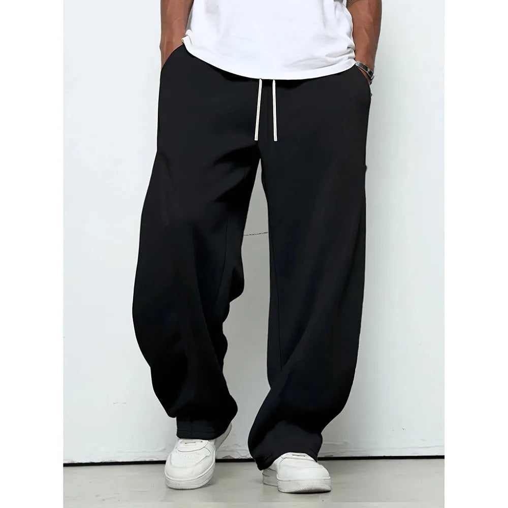 Man wearing solid grey straight-leg casual trousers with an elasticated waistband.
