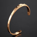 Open-ended stainless steel women's bracelet with inlaid zircon stones in gold colour.