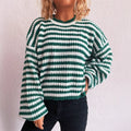 Woman wearing a loose-fitting black and white stripe pullover sweater with a round neck and long sleeves.