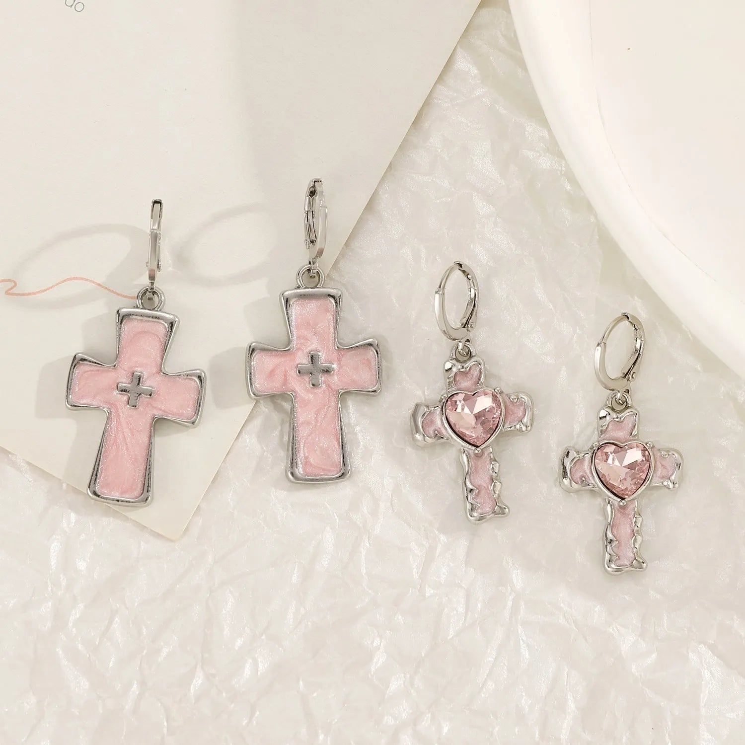 Women's alloy earrings with cross and character designs in five colour options including white cross and antique silver