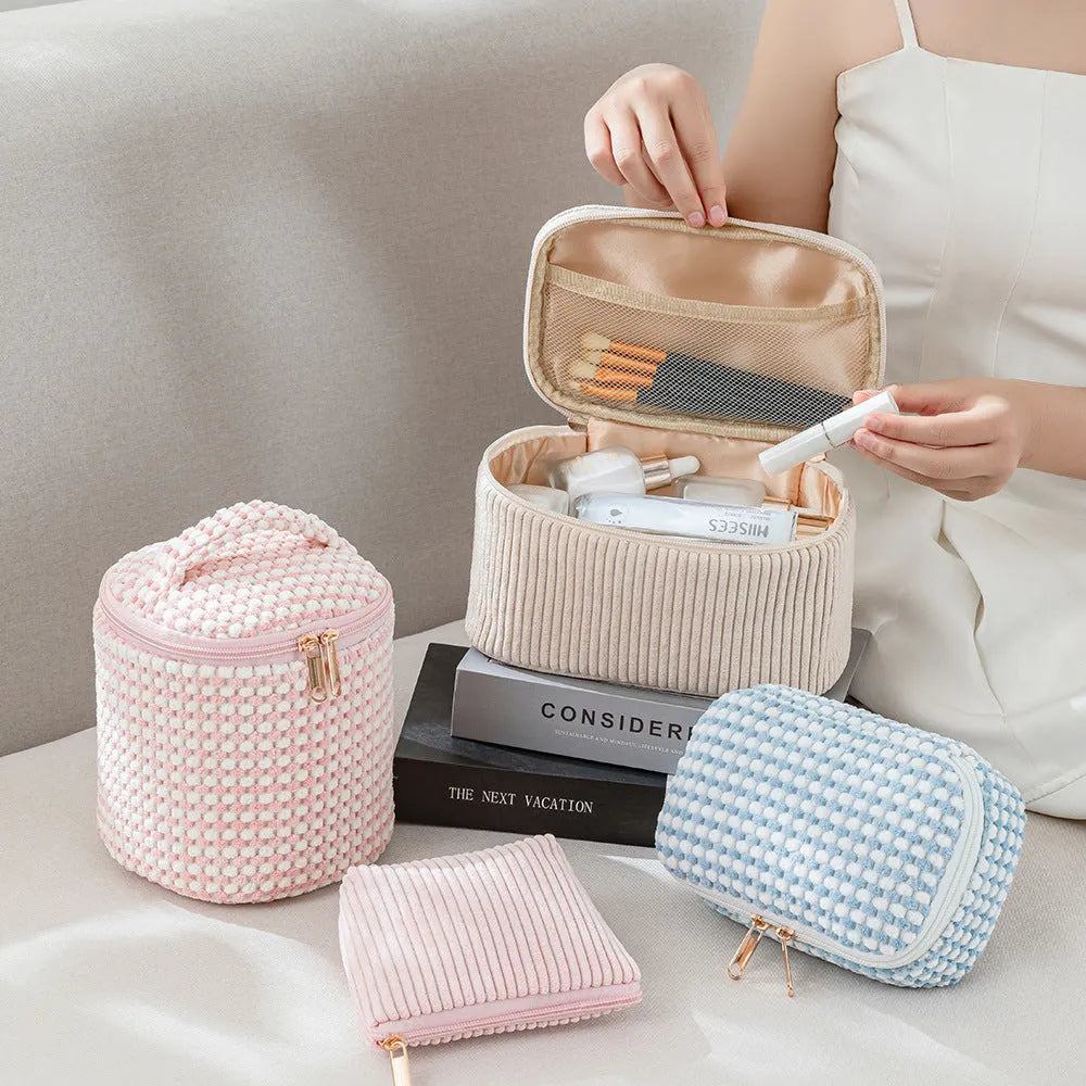 Four cube-style polyester makeup bags in different colour patterns including pink, khaki, and dotted designs