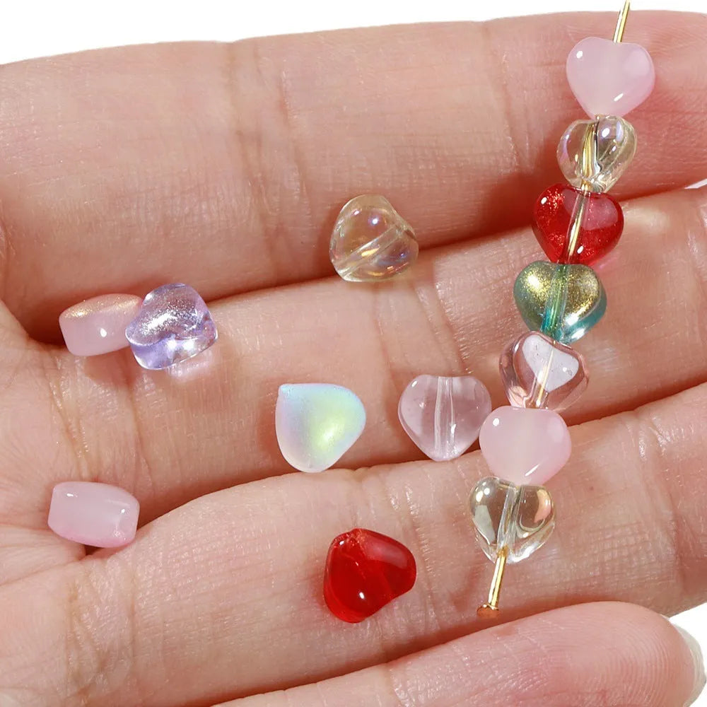 20 transparent acrylic love heart beads in assorted colours on white background