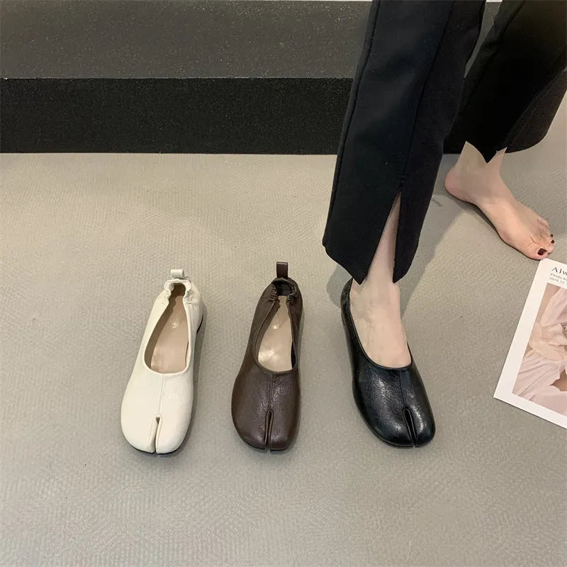 Women's black low heel pumps with chunky heel and round toe showing split toe horseshoe detail