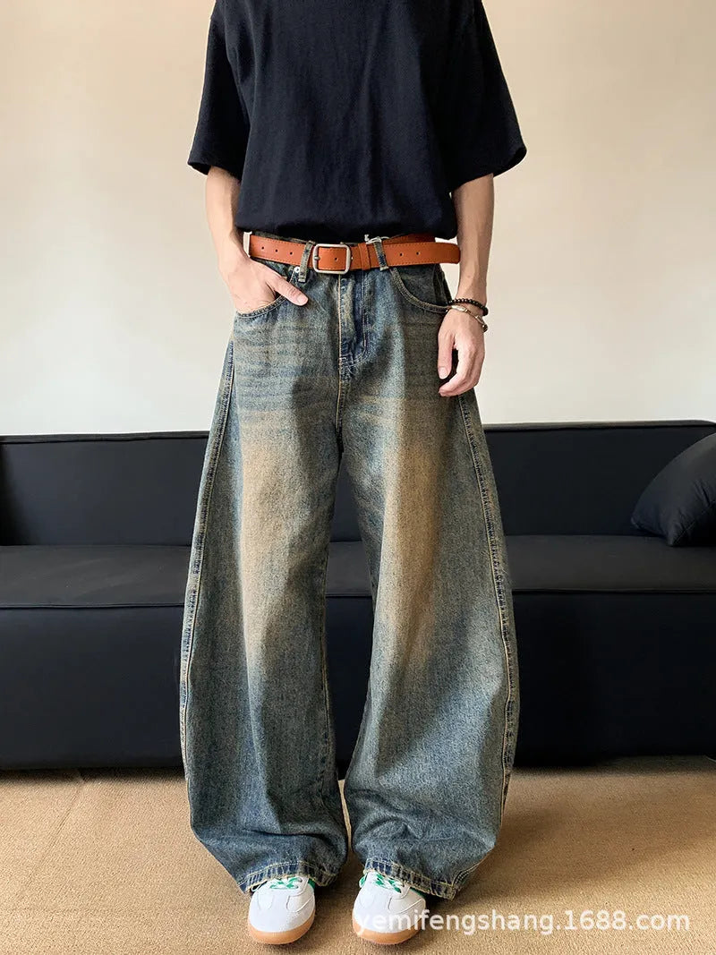 Man wearing retro blue distressed denim wide-leg trousers with a slim fit and zipper fly