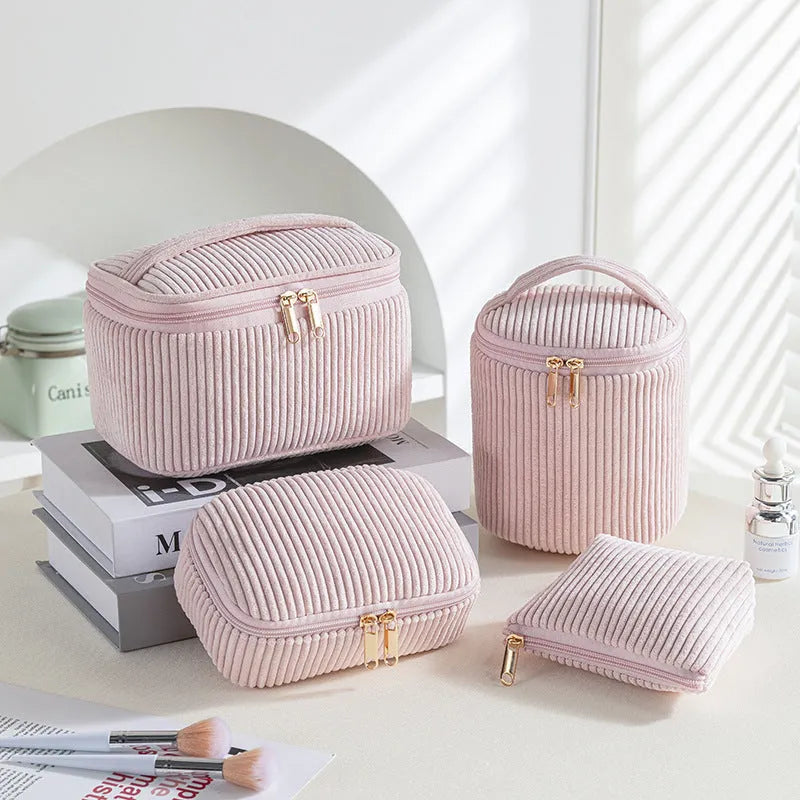 Four cube-style polyester makeup bags in different colour patterns including pink, khaki, and dotted designs