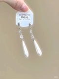 Close-up of women's geometric alloy earrings with rhinestones, a dangling tassel, and a heart detail.