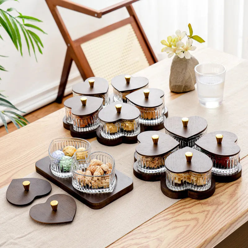 Glass foot bath fruit platter with coloured glaze and transparent heart-shaped lids on a multi-grid snack tray.