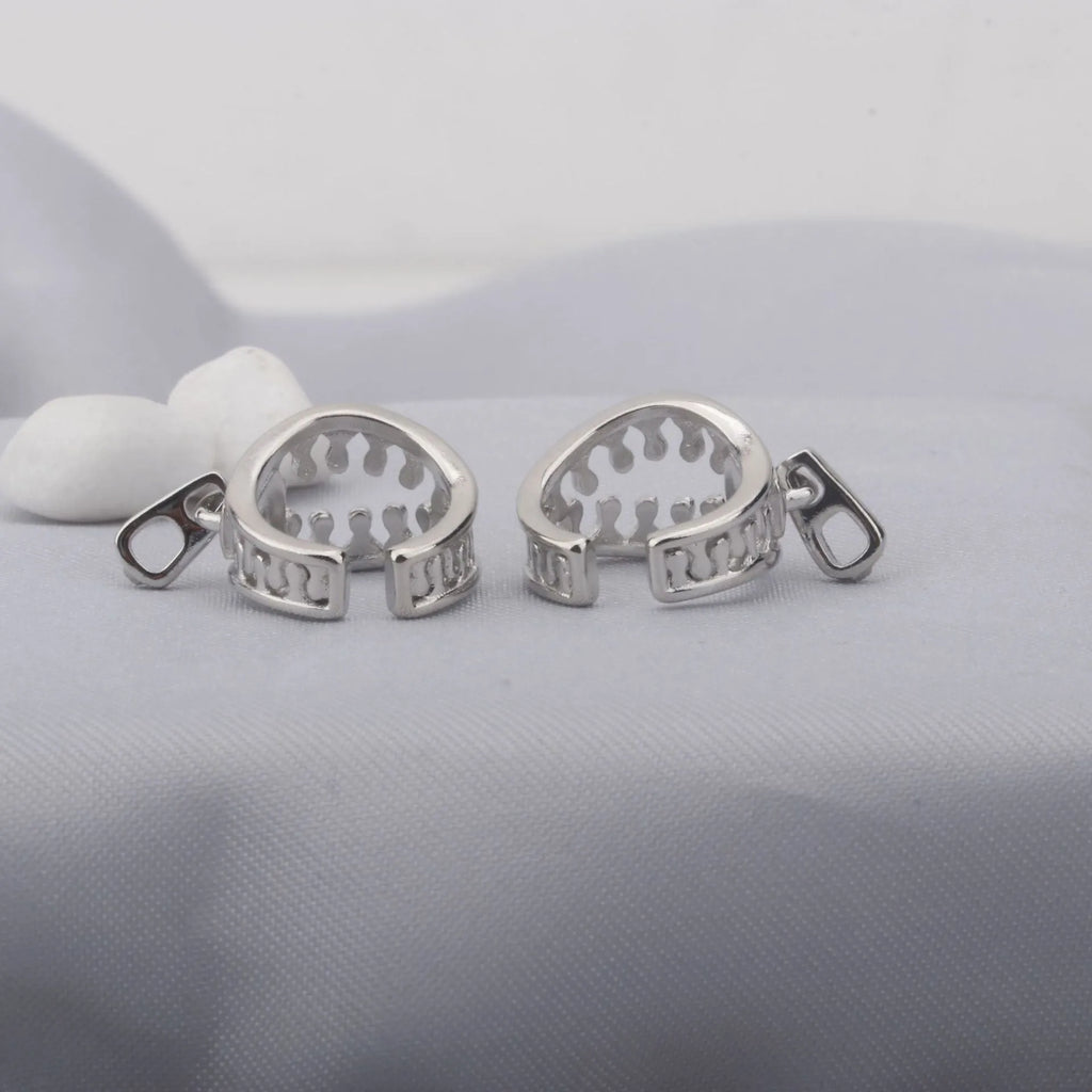 A pair of simple geometric copper ear clips with linear design and a zipper closure, colour ES862.