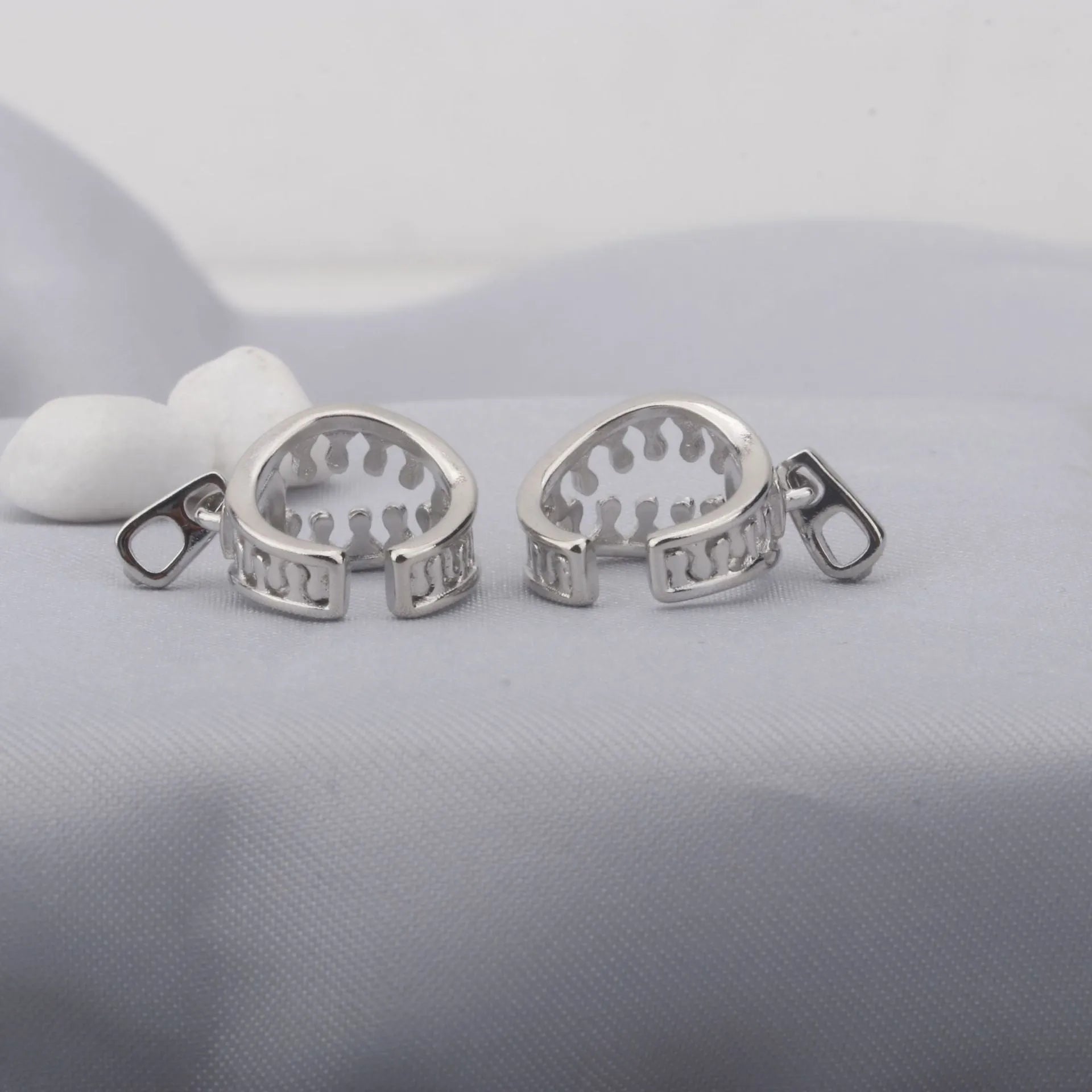 A pair of simple geometric copper ear clips with linear design and a zipper closure, colour ES862.