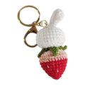 White hand-woven wire pendant in shape of a rabbit with a strawberry pattern, includes a key.