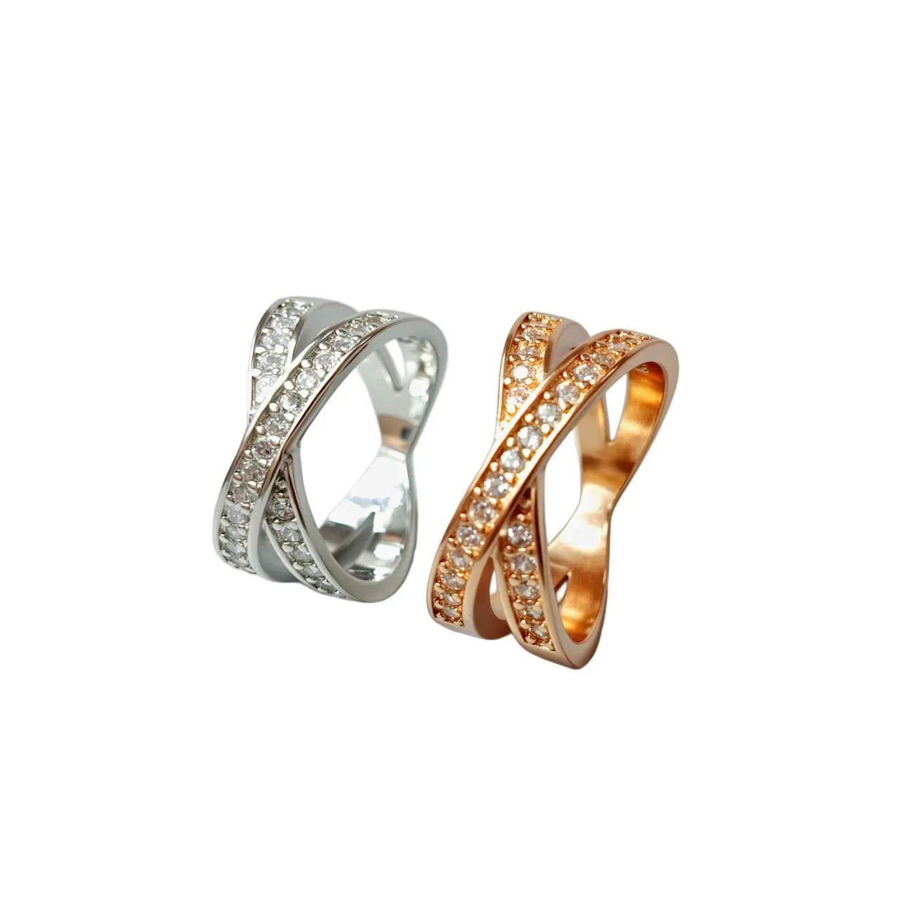 A silver or rose gold metal ring featuring a central cross design with small zircon stones.