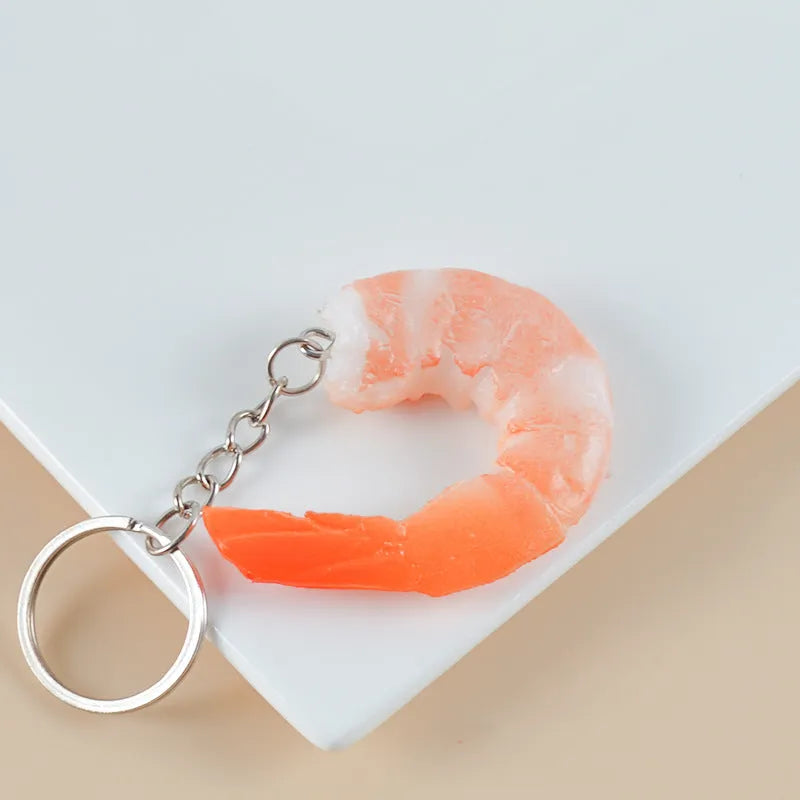 Solid PVC shrimp-shaped keychain with metal loop, 1.5cm thick, modern design.