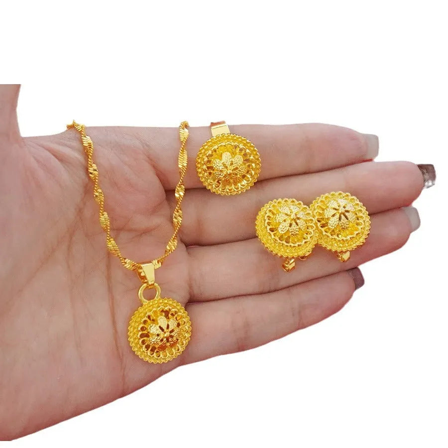 Three-piece gold-plated jewellery set with floral design including pendant necklace, earrings and ring