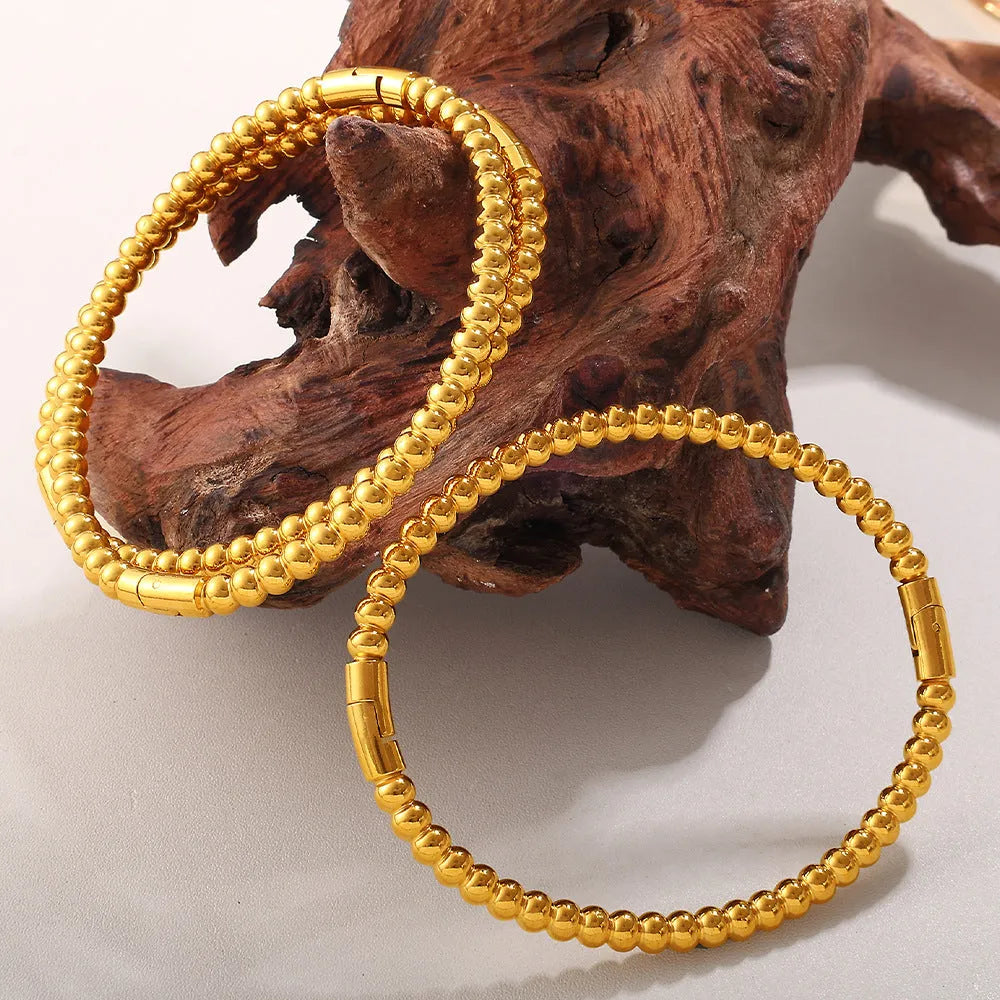 Stainless steel open-end buckle bracelet with electroplated finish, available in gold, white zirconium, and white diamond colours