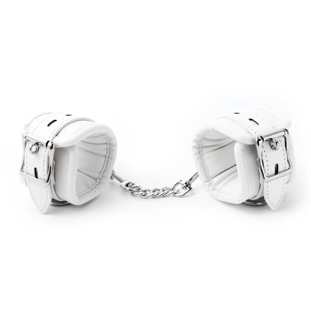 White PU sponge bondage ankle cuff and handcuff set with matching neck scarf on plain background