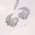 Pair of gold electroplated stainless steel leaf-shaped stud earrings on a white background