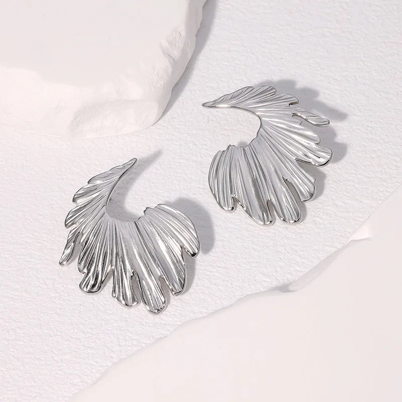 Pair of gold electroplated stainless steel leaf-shaped stud earrings on a white background